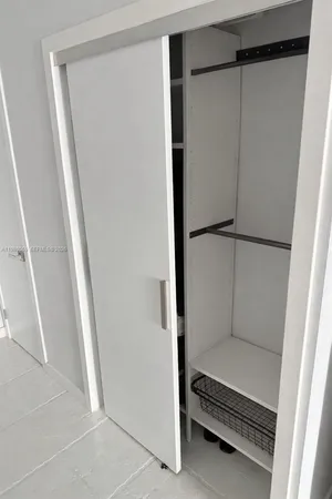 a view of walk in closet with empty racks