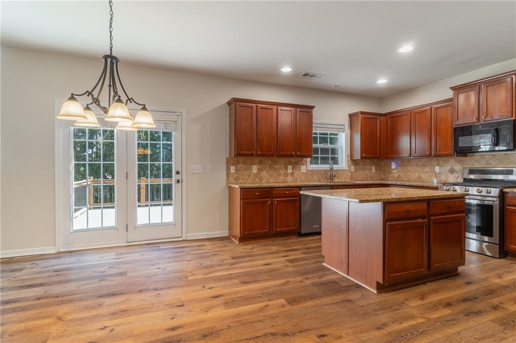206 Sawtooth Court Canton, GA 30114 - Photo 10 of 43 a kitchen with stainless steel appliances granite countertop a stove a sink dishwasher a refrigerator and a wooden floor