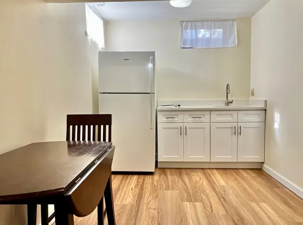a view of a kitchen with cabinets and wooden floor
