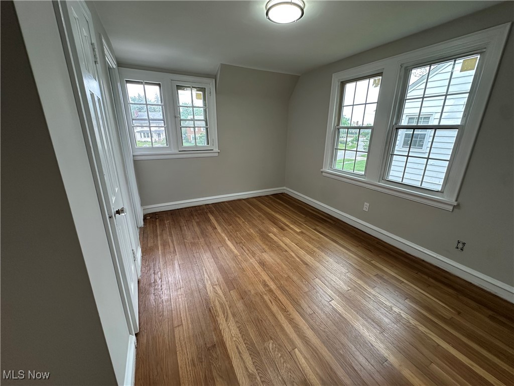 13707 Drexmore Road Cleveland, OH 44120 - Photo 16 of 35 Spare room with healthy amount of natural light, wood-type flooring, and baseboards