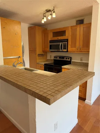 a kitchen with stainless steel appliances granite countertop a sink and a microwave