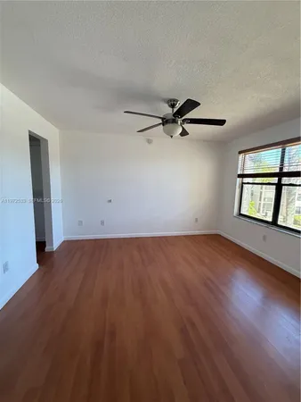 an empty room with windows and ceiling fan view