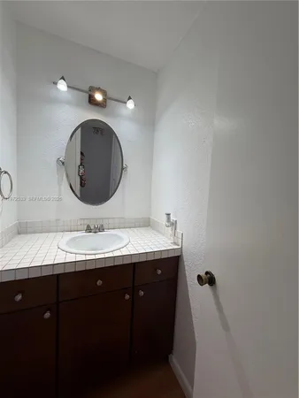 a bathroom with a granite countertop double vanity sink and mirror
