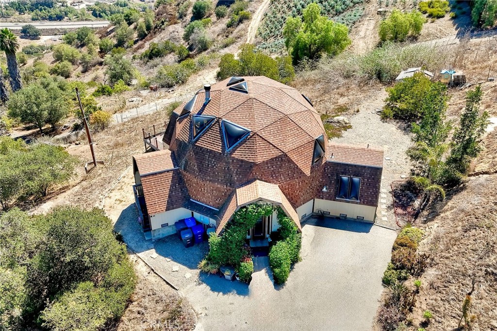 an aerial view of a house with a yard and a large tree