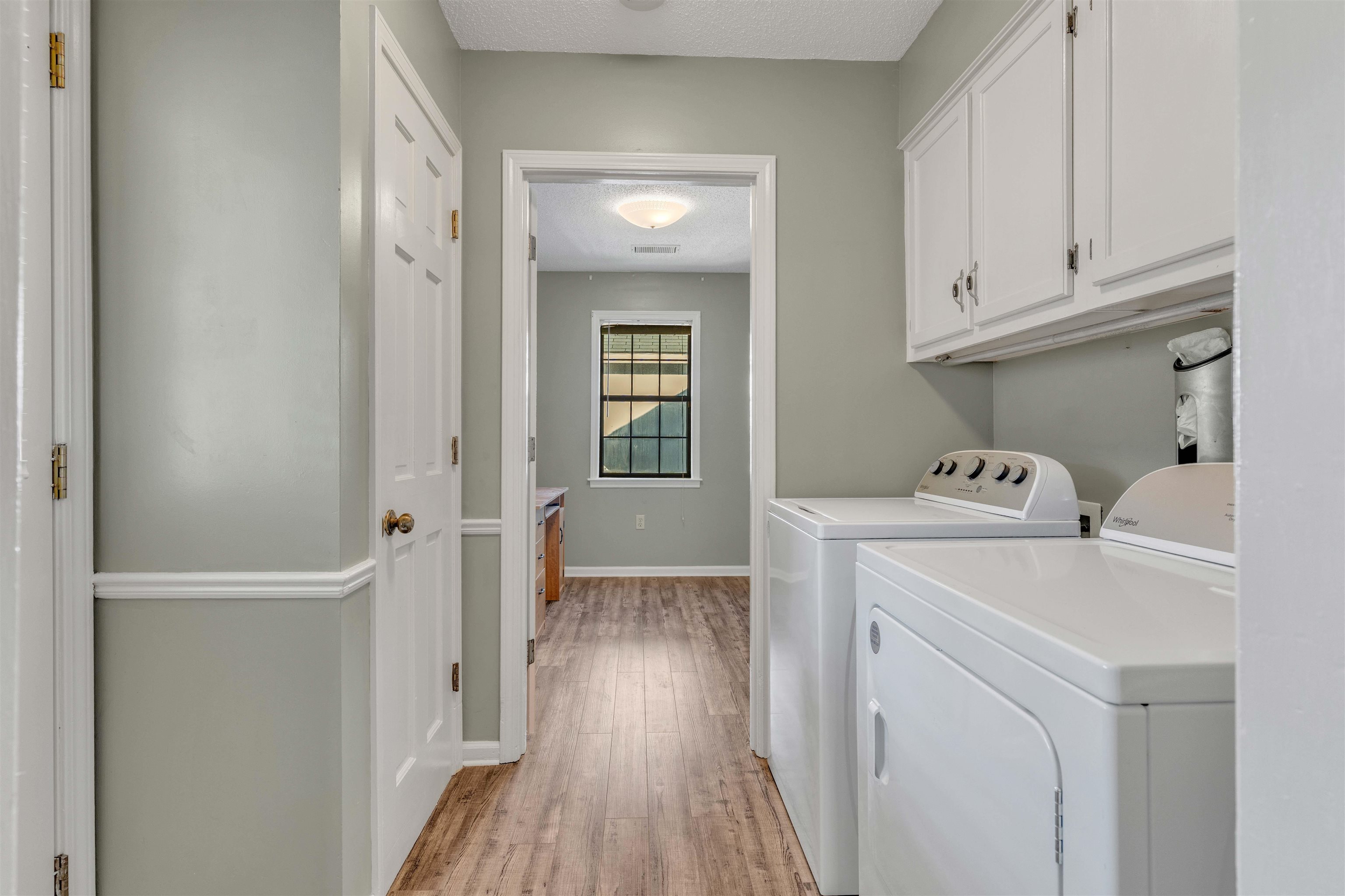 301 East Harpers Ferry Road Collierville, TN 38017 - Photo 18 of 39 Laundry room with a textured ceiling, independent washer and dryer, light wood-style floors, and cabinet space