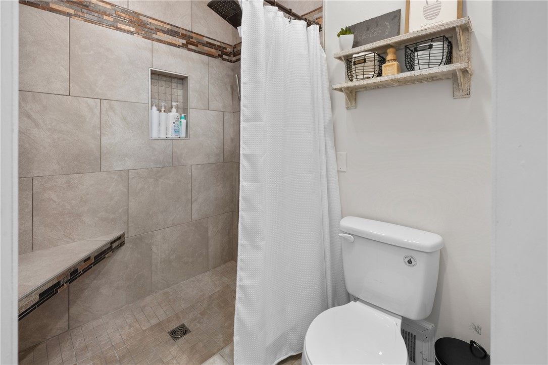 203 Augusta Road Clemson, SC 29631 - Photo 22 of 31 A well-appointed shower space offers convenient built-in shelving and bench seating.