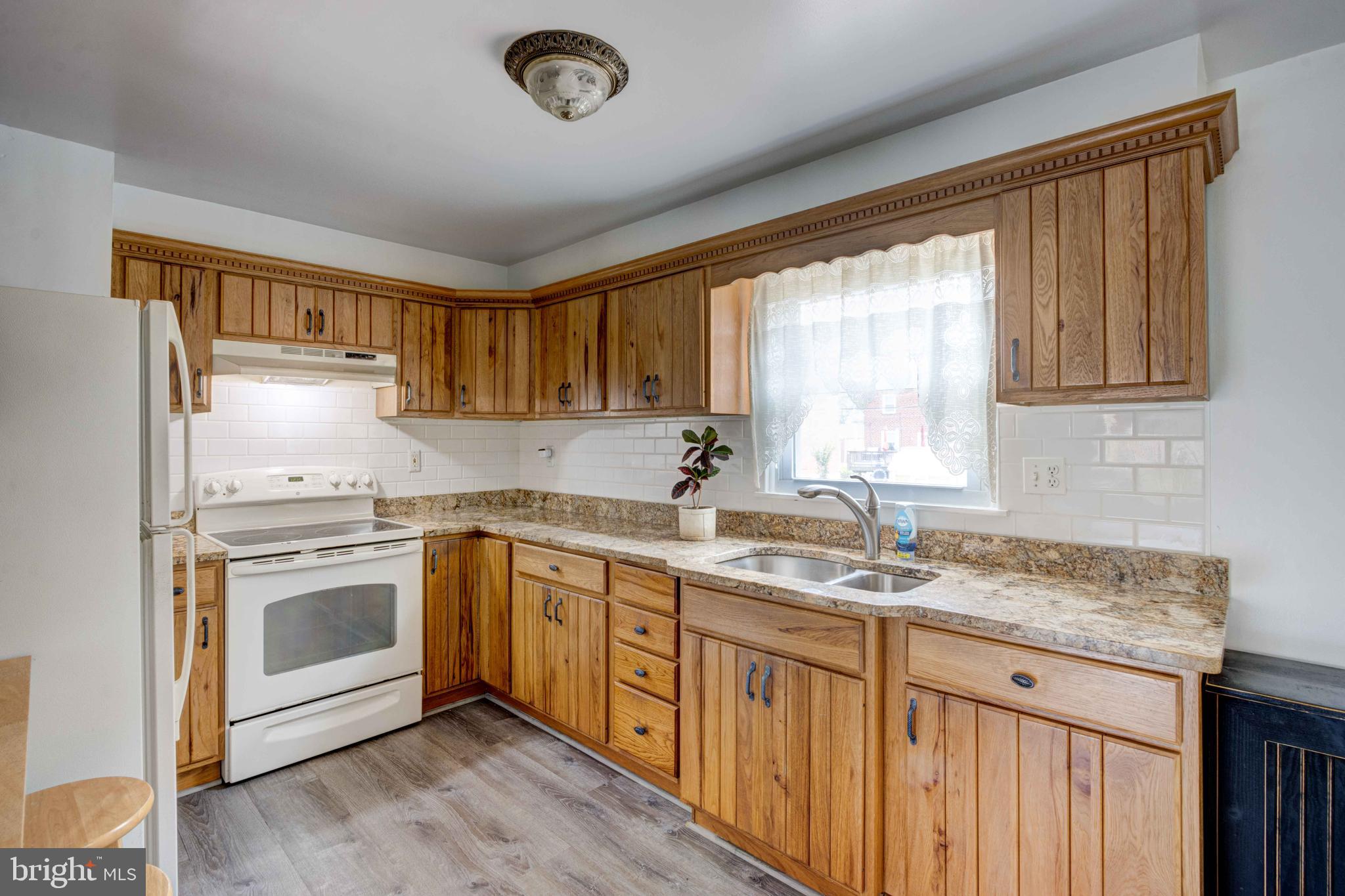 5621 Chelwynd Road Halethorpe, MD 21227 - Photo 6 of 22 a kitchen with granite countertop a sink stainless steel appliances and cabinets