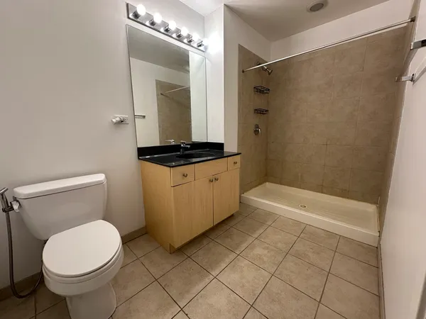 a bathroom with a granite countertop sink toilet and shower