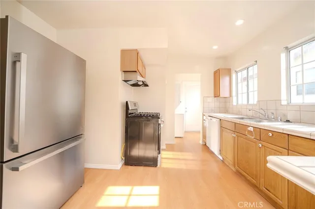 a kitchen with granite countertop a sink stainless steel appliances and window