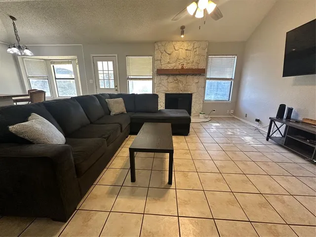 a living room with couches a fireplace and a flat screen tv