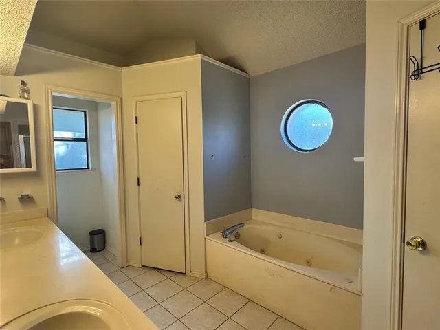a bathroom with a tub a sink and a mirror