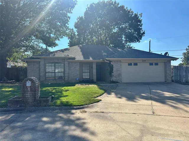 a view of a white house with a yard and a large tree