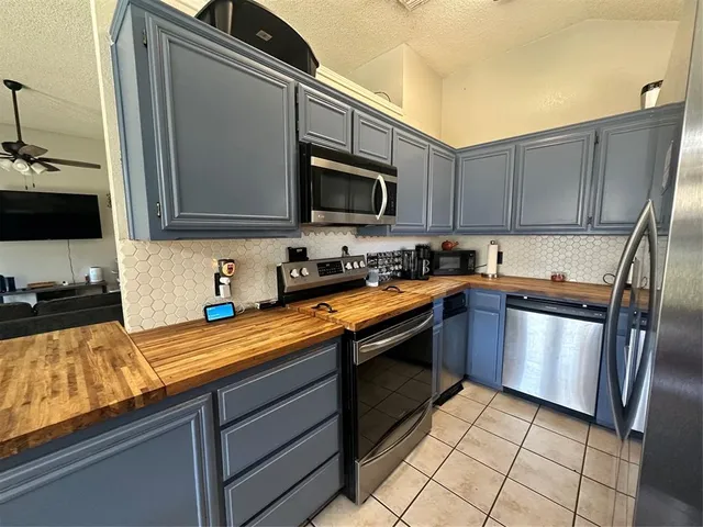 a kitchen with stainless steel appliances granite countertop a sink stove and microwave