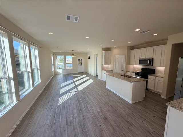 a view of a living room a kitchen and a wooden floor