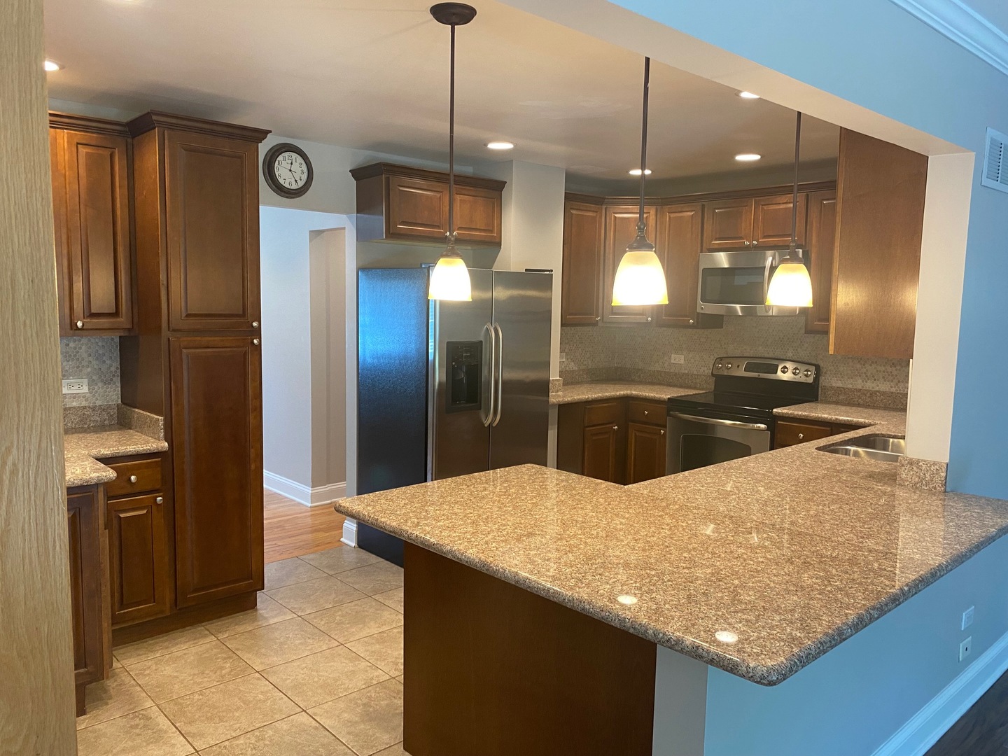 1009 Dell Road Northbrook, IL 60062 - Photo 4 of 15 a kitchen with stainless steel appliances kitchen island granite countertop a refrigerator a sink and a wooden cabinets