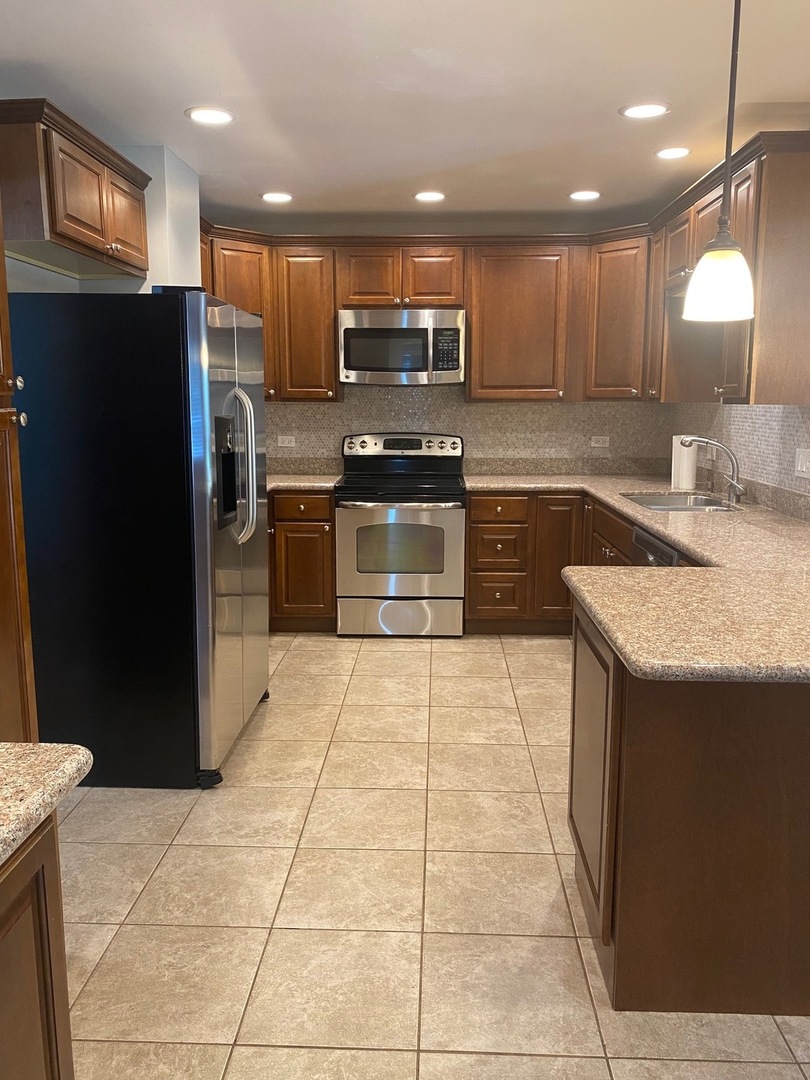 1009 Dell Road Northbrook, IL 60062 - Photo 5 of 15 a kitchen with stainless steel appliances granite countertop a refrigerator and a stove top oven