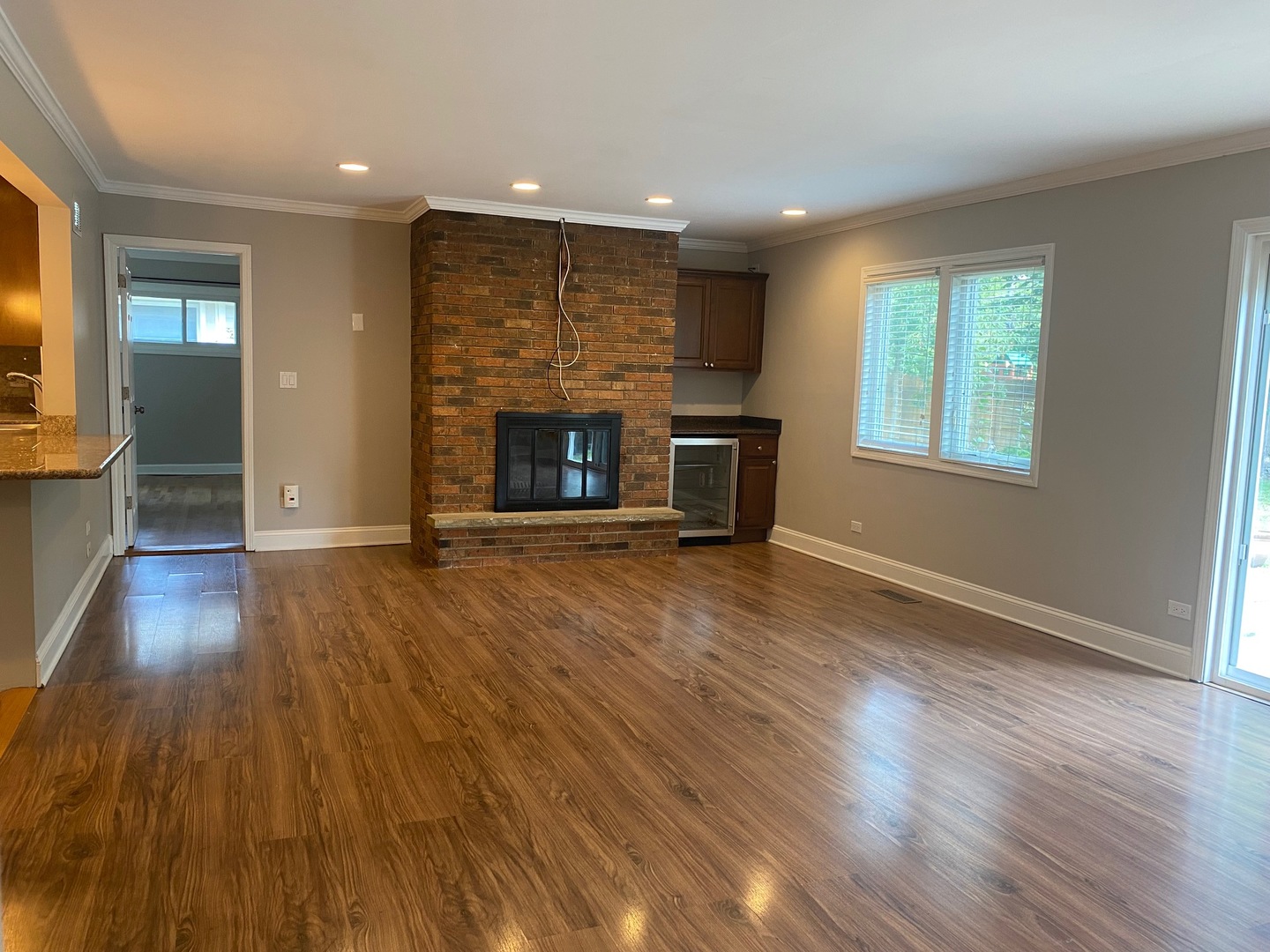 1009 Dell Road Northbrook, IL 60062 - Photo 6 of 15 an empty room with wooden floor fireplace and windows