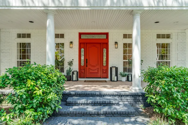 a view of a house with a yard and a large tree
