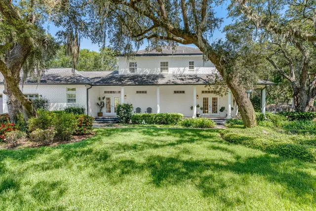 a living room with furniture hard wood floor and a floor to ceiling window