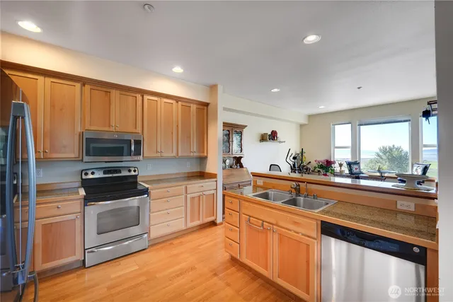 a kitchen with stainless steel appliances a stove sink and microwave