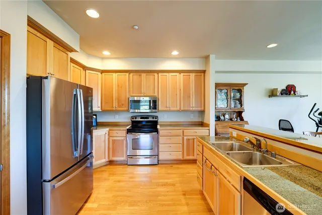 a kitchen with granite countertop a refrigerator and a sink