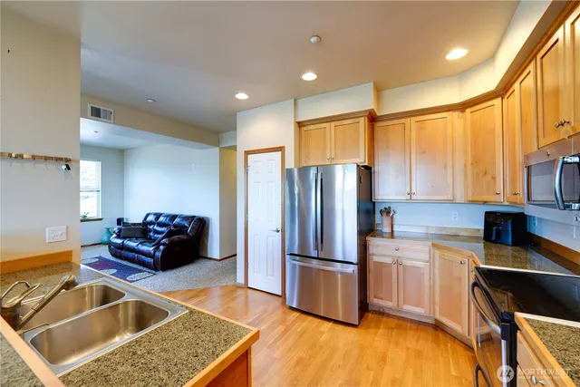 a kitchen with granite countertop a refrigerator and a sink