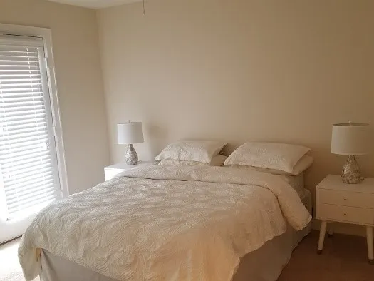 a large bed sitting in a bedroom next to a window