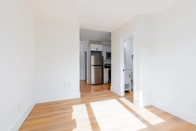a view of a hallway with wooden floor and entryway