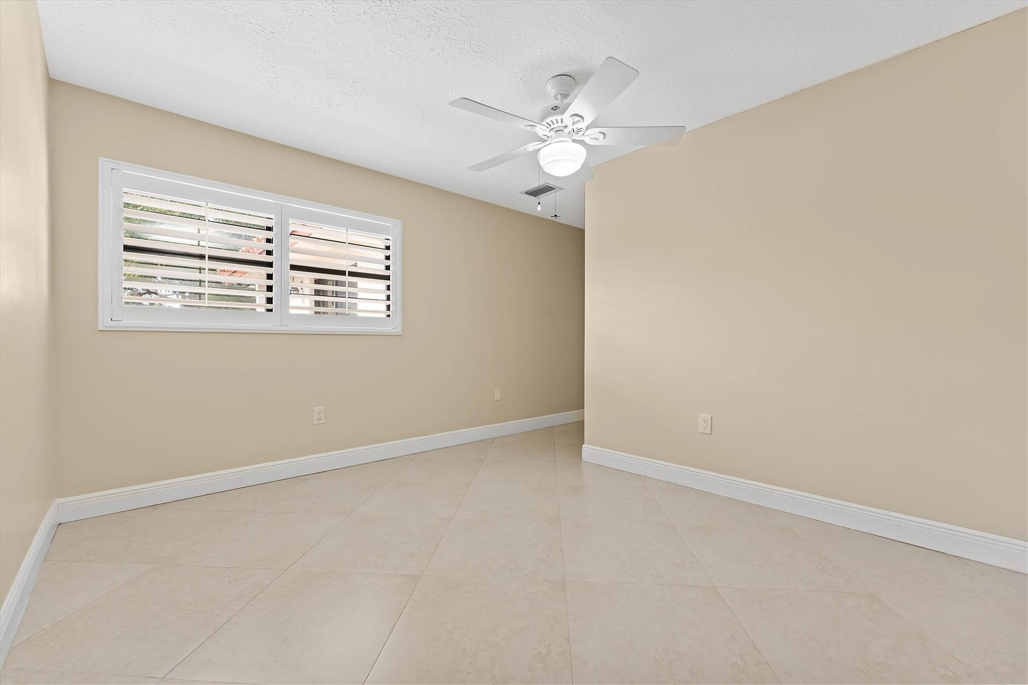 11288 Southwest 59th Court Cooper City, FL 33330 - Photo 16 of 32 an empty room with windows and chandelier fan