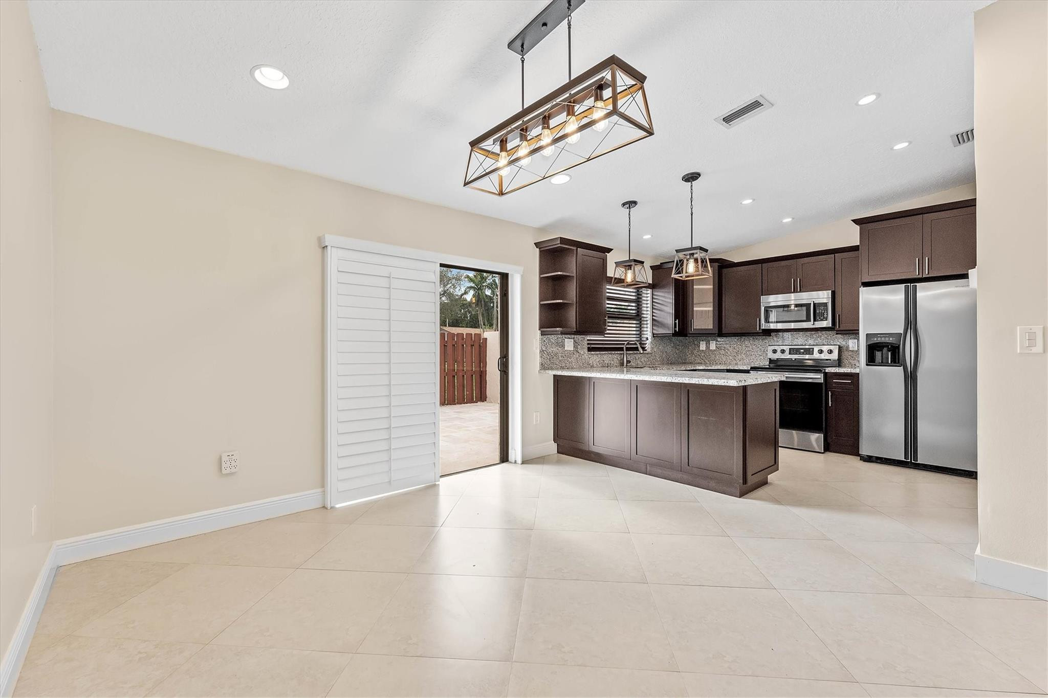 11288 Southwest 59th Court Cooper City, FL 33330 - Photo 7 of 32 a large kitchen with stainless steel appliances kitchen island granite countertop a refrigerator and a sink