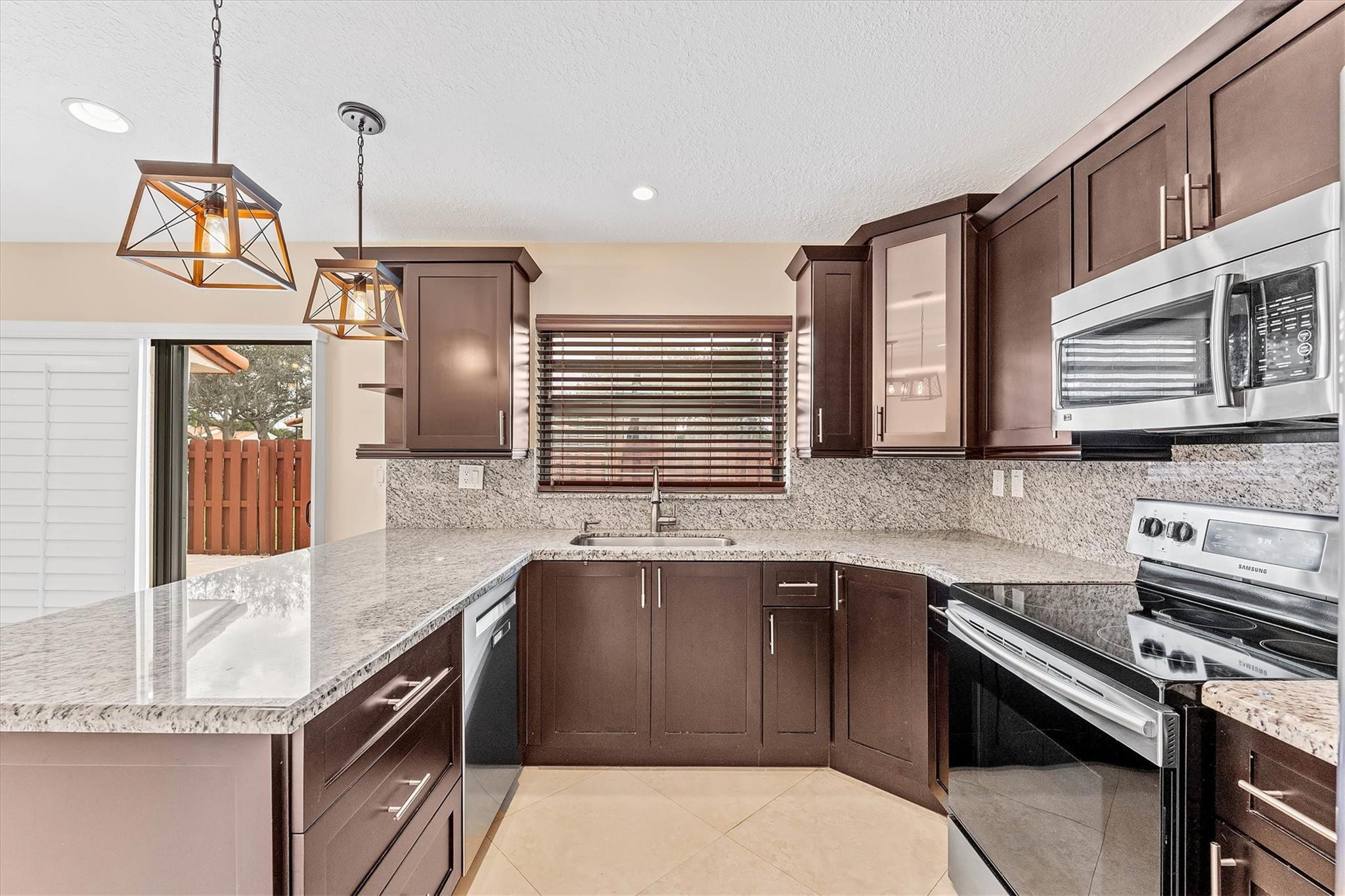 11288 Southwest 59th Court Cooper City, FL 33330 - Photo 9 of 32 a kitchen with stainless steel appliances granite countertop a sink stove and cabinets