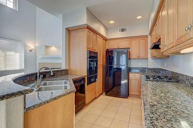 a kitchen with stainless steel appliances granite countertop a sink stove and refrigerator