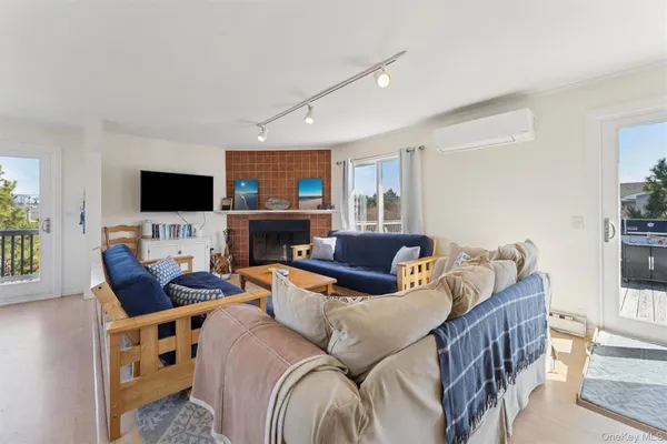 a living room with furniture a flat screen tv and a fireplace