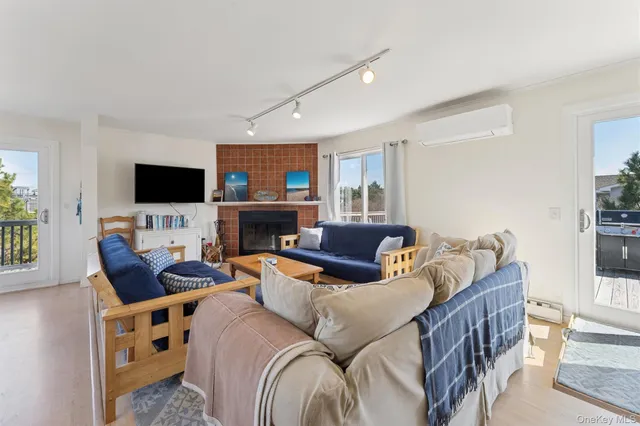 a living room with furniture a flat screen tv and a fireplace