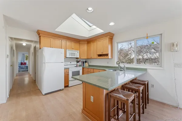 a kitchen that has a lot of white cabinets and stainless steel appliances