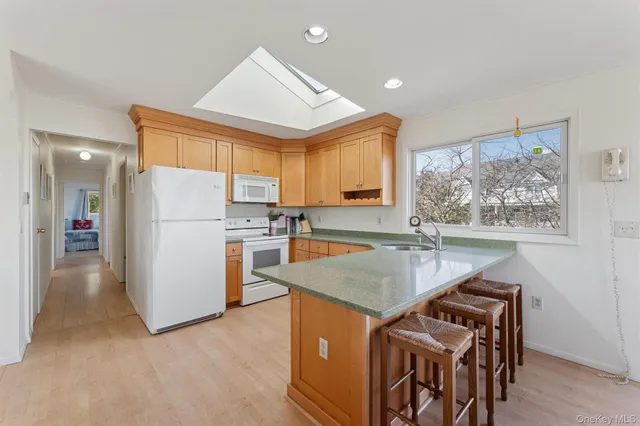 a kitchen that has a lot of white cabinets and stainless steel appliances