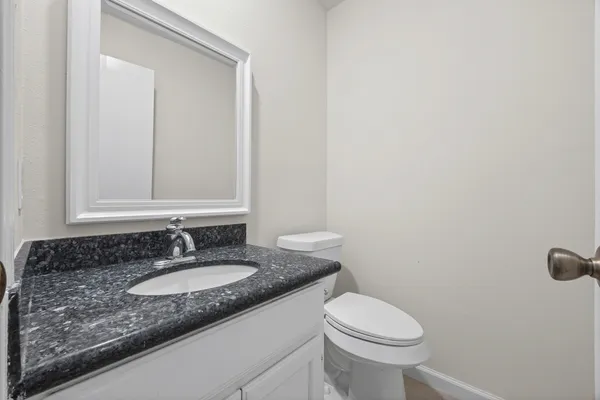 a bathroom with a granite countertop sink and a mirror