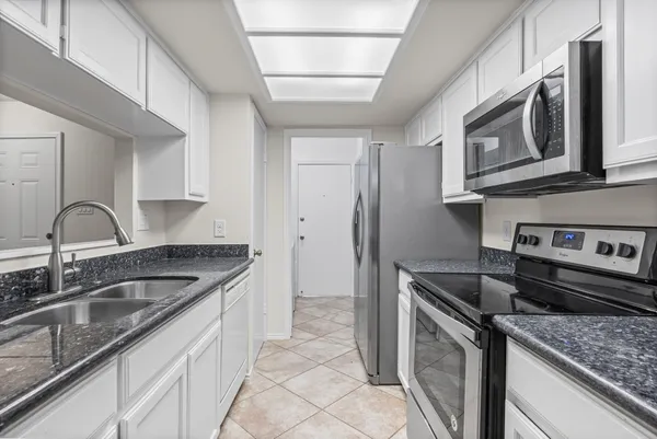 a kitchen with stainless steel appliances granite countertop a sink stove and microwave