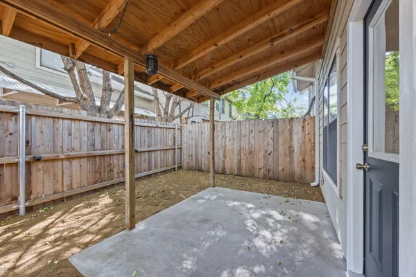 a view of backyard with tub and wooden fence