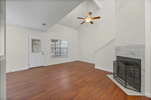 a view of empty room with wooden floor and fireplace