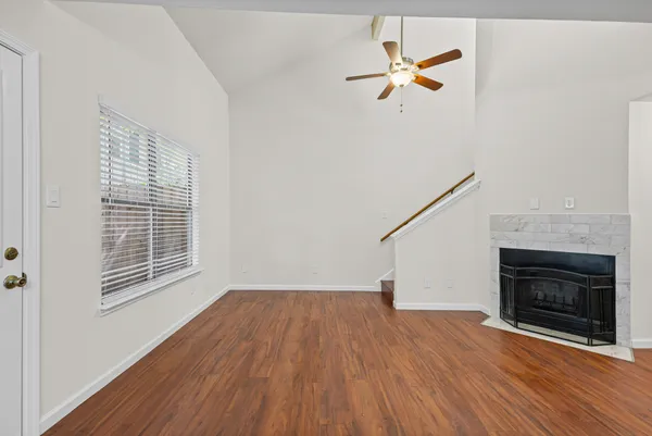 a view of empty room with wooden floor and a fireplace