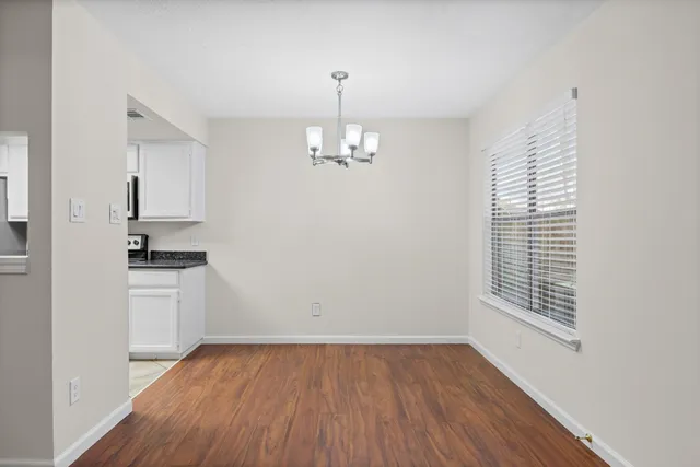a view of a kitchen with wooden floor and a window