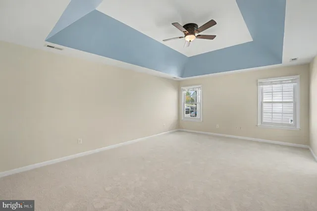 an empty room with a ceiling fan and window