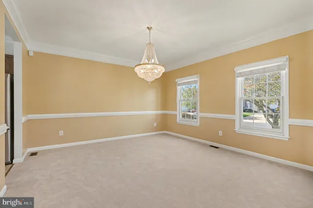 an empty room with windows and chandelier