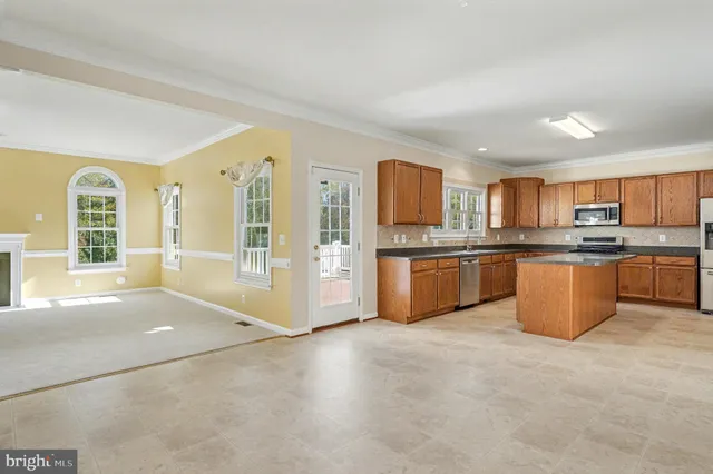a large kitchen with cabinets a sink and stainless steel appliances
