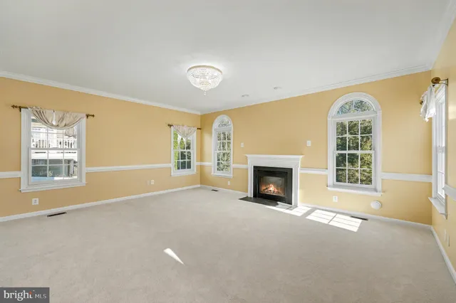 a view of an empty room with a fireplace and a window