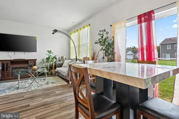 a dining room with furniture window and wooden floor