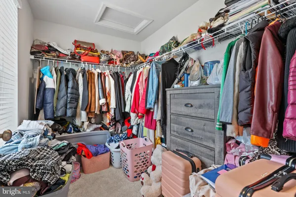 a view of walk in closet with clothes