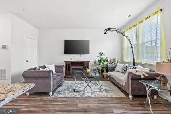 a living room with furniture a flat screen tv and a large window