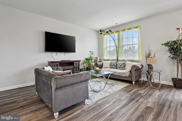 a living room with furniture a flat screen tv and a large window